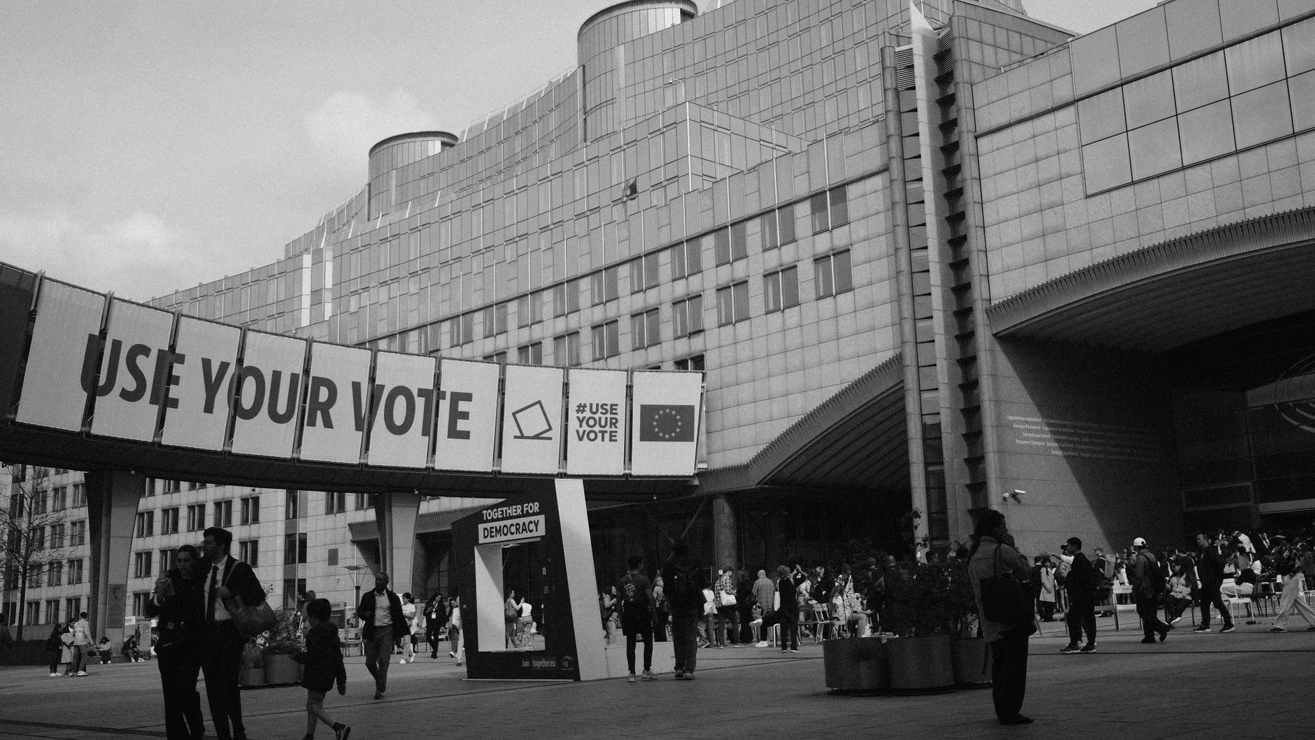 Black and white photo of European Parliament in Brussels with 'Use Your Vote' sign.