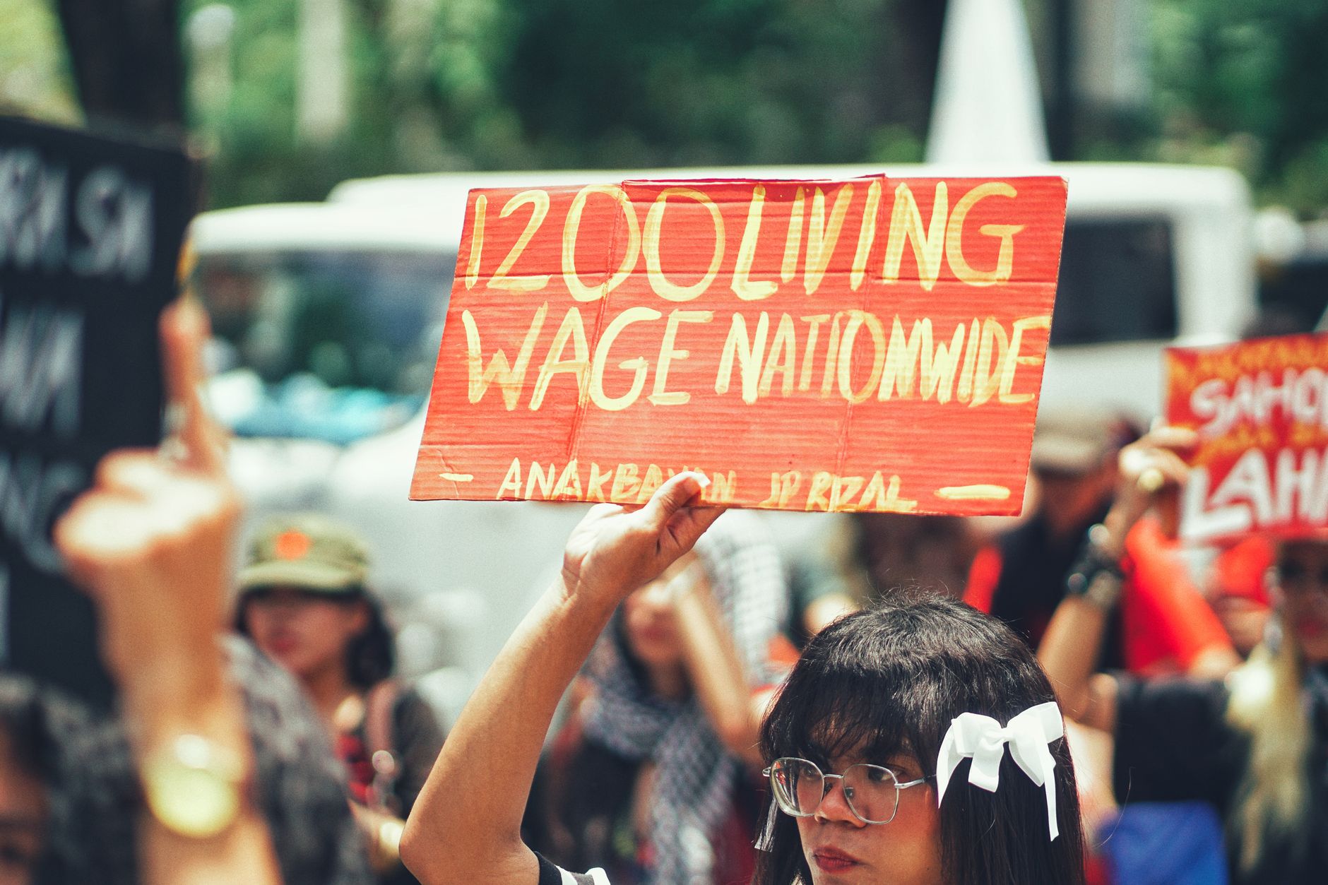 A group of protestors holding a sign demanding a 1200 living wage nationwide.