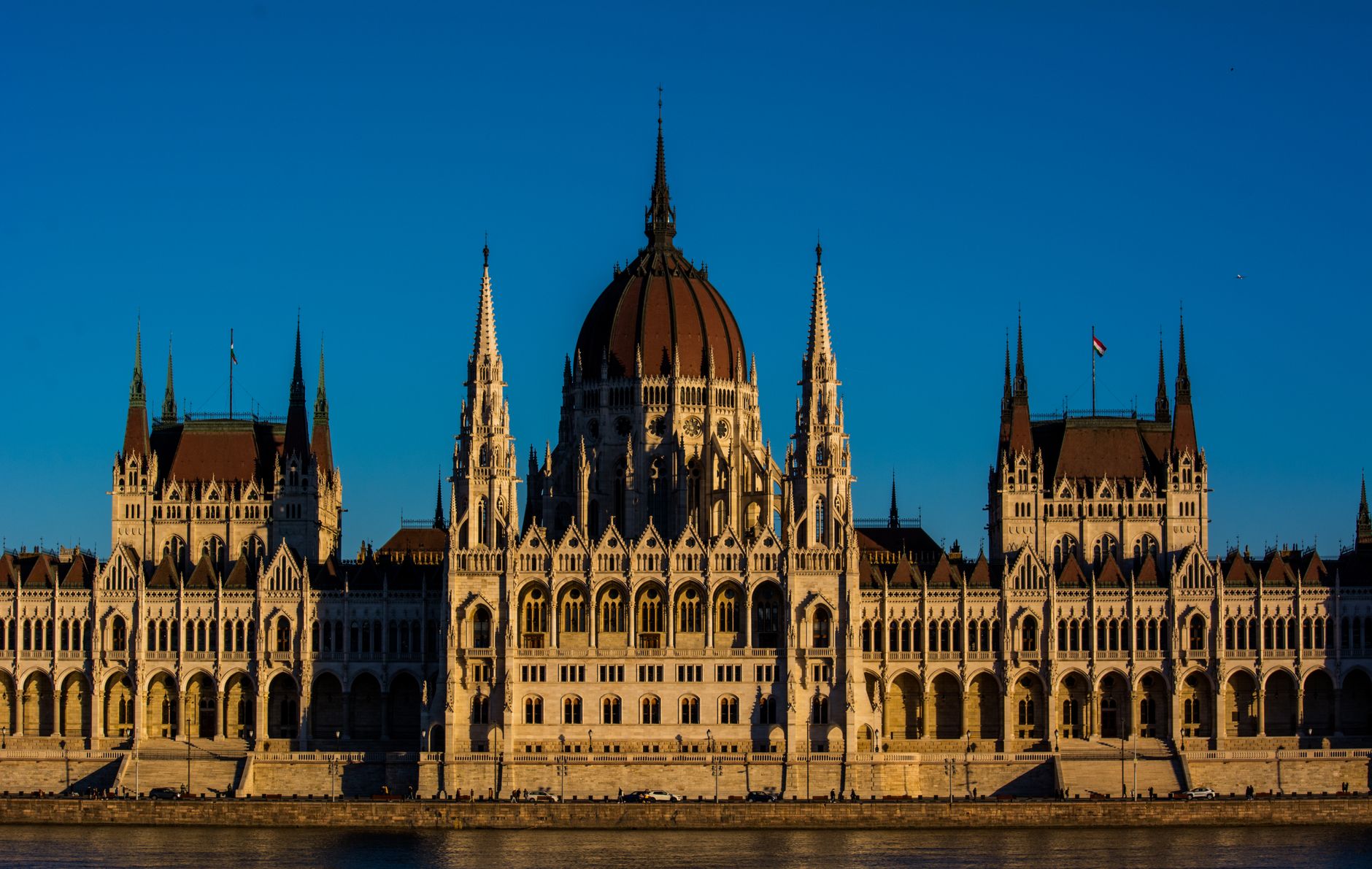 Breathtaking view of the Hungarian Parliament Building bathed in warm sunset light, showcasing its Gothic Revival architecture.