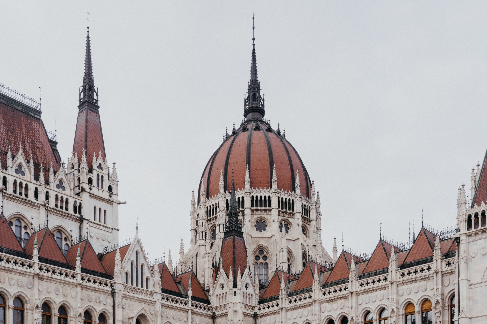 Elegant neo-gothic architecture of the Hungarian Parliament in Budapest under an overcast sky.