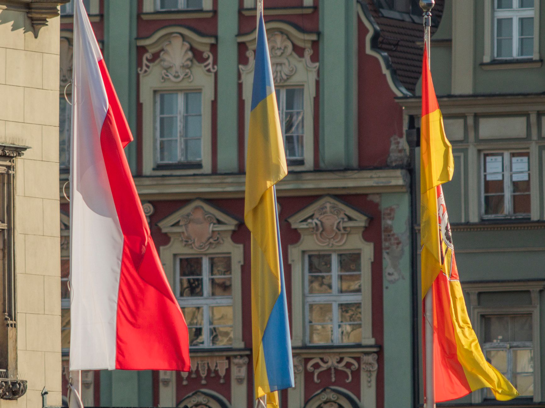 Flags of Poland, Ukraine, and Spain displayed in Wrocław's city center.