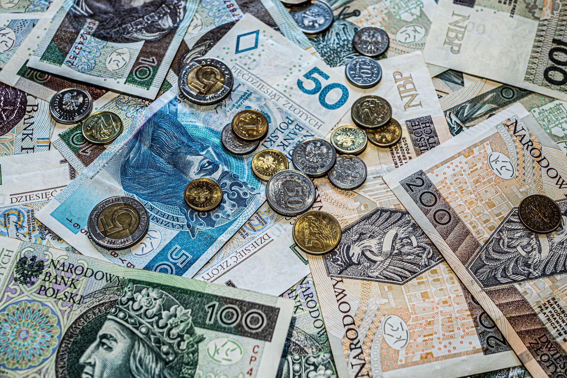 Close-up of Polish złoty currency, including various banknotes and coins scattered.