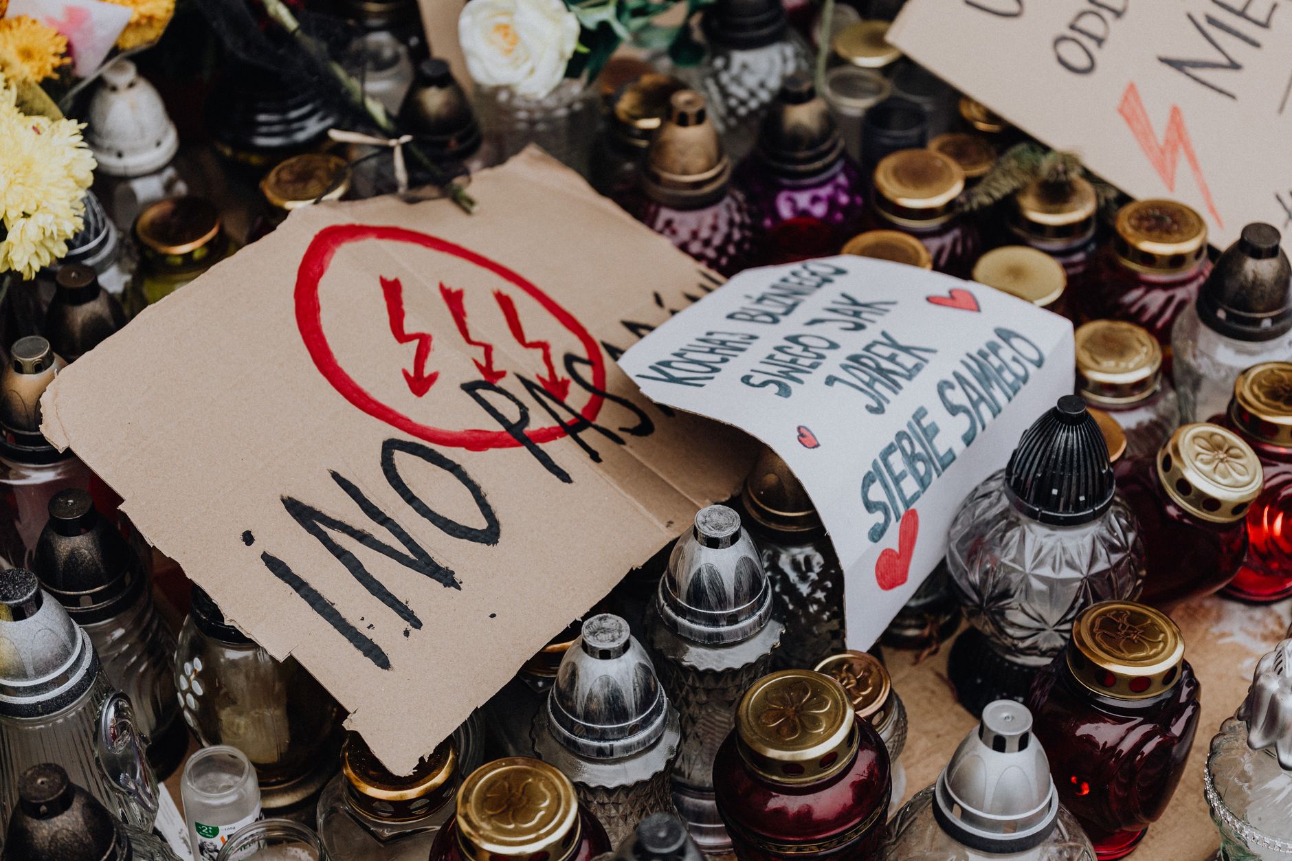A dynamic scene of a Polish demonstration with candles and protest signs advocating change.