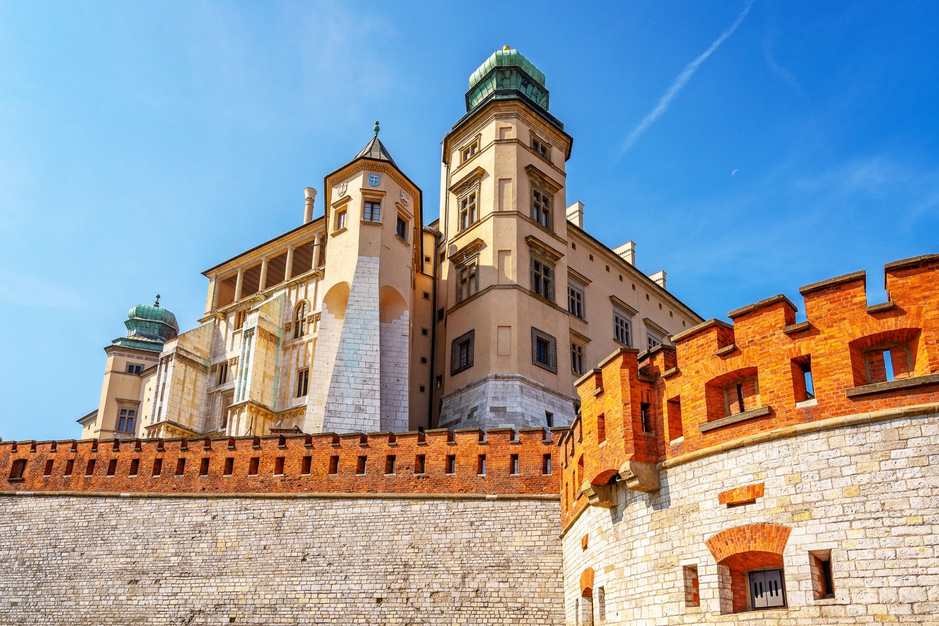 Historic Wawel Castle in Krakow, Poland, captured in vibrant sunlight against a clear blue sky.