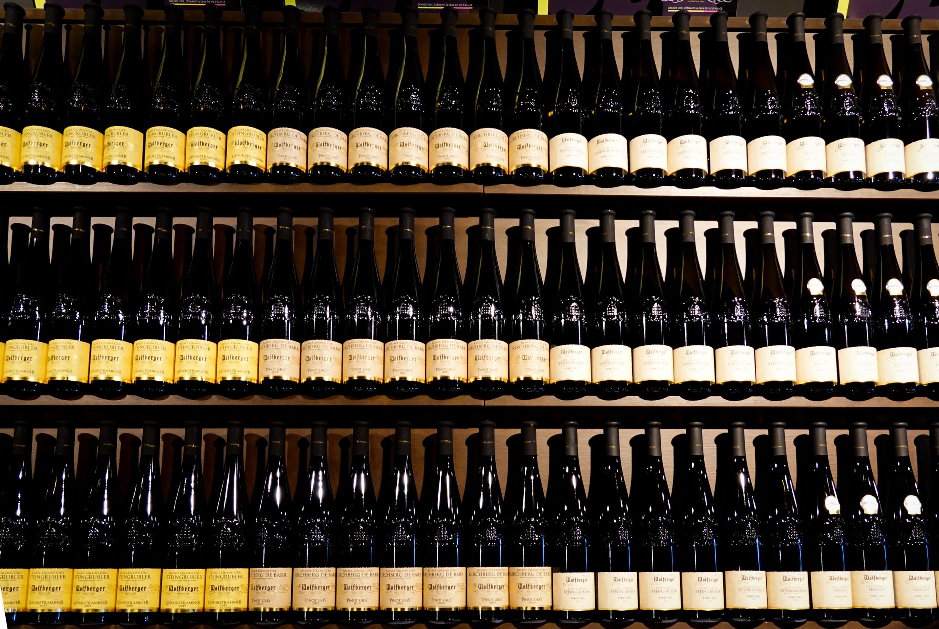 A neatly arranged collection of wine bottles on shelves in a store.
