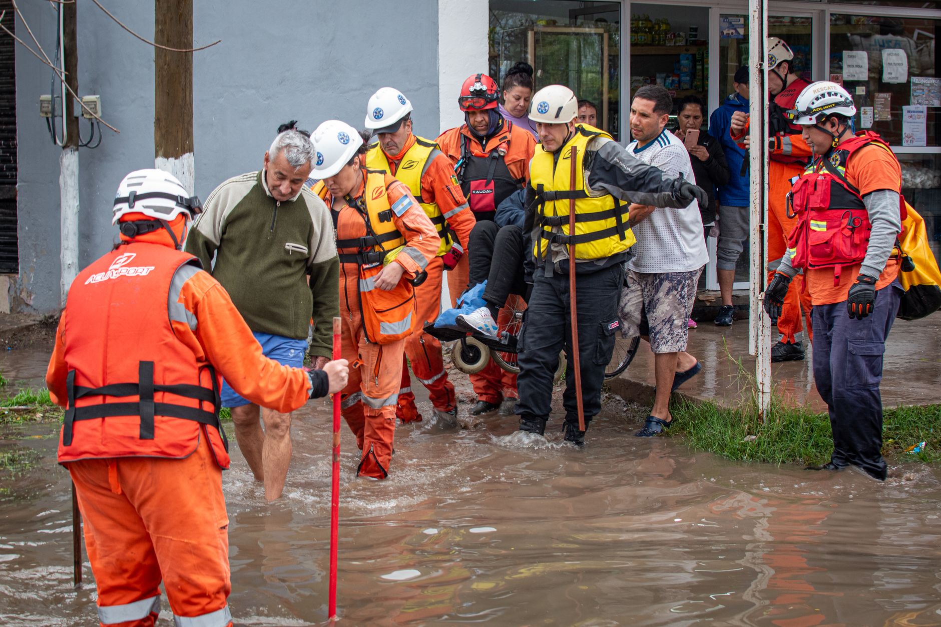 Emergency responders help people during a street flood rescue operation.