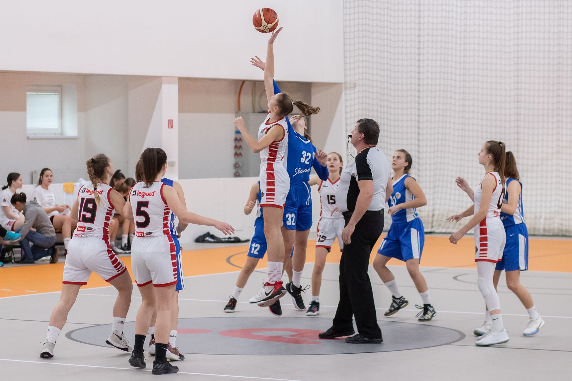 Dynamic basketball scene with players in action on an indoor court.