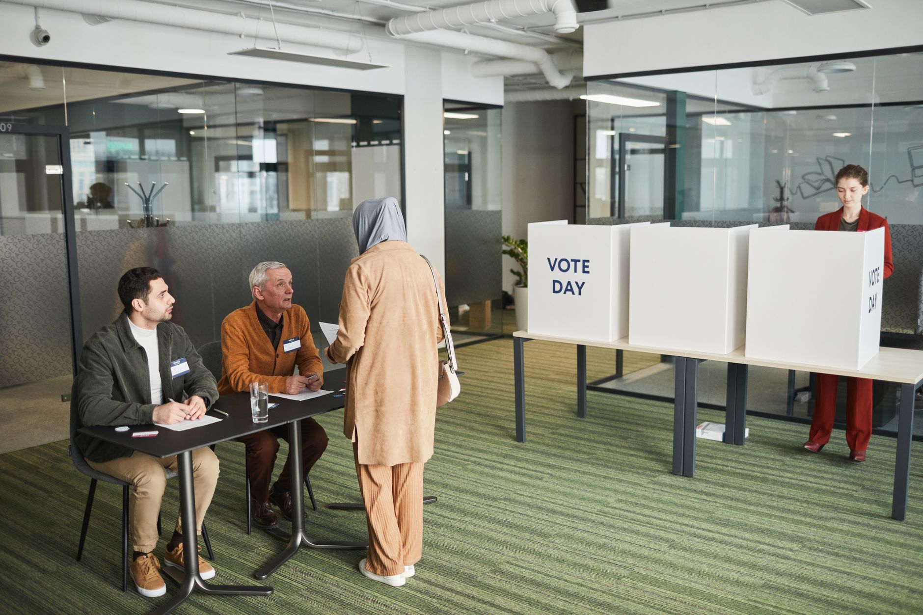 A diverse group of people in an office setting participating in election day activities.