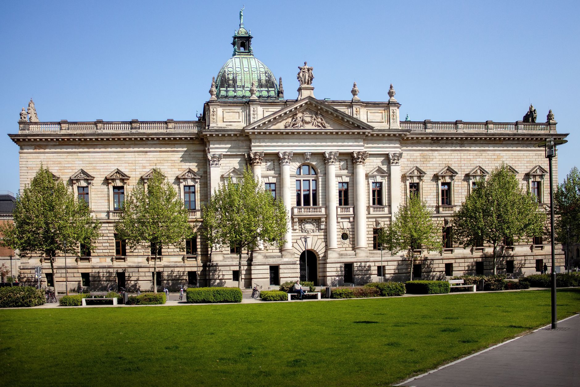Front view of the Federal Administrative Court in Leipzig, Germany with a green lawn and clear sky.